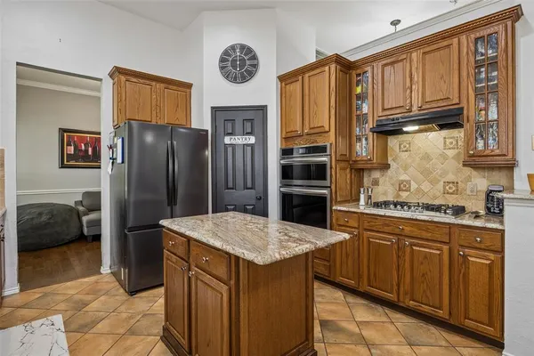 a kitchen with stainless steel appliances granite countertop a refrigerator and a stove top oven