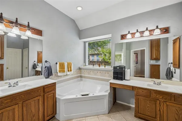 a bathroom with a tub sink and mirror