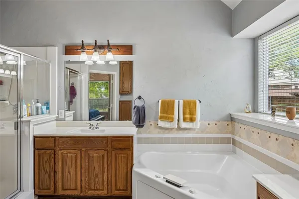 a bathroom with a tub sink and mirror
