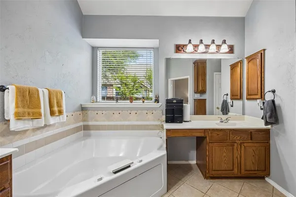 a bathroom with a tub sink and a mirror