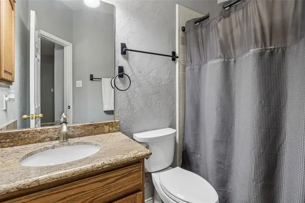a bathroom with a granite countertop toilet sink and shower