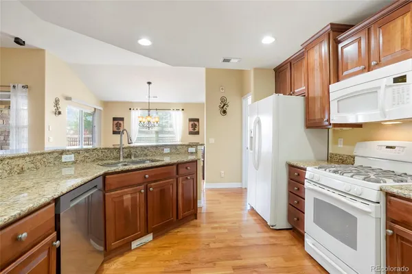 a kitchen with stainless steel appliances granite countertop a refrigerator and a stove top oven