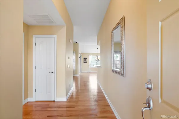 a view of a hallway with wooden floor and staircase