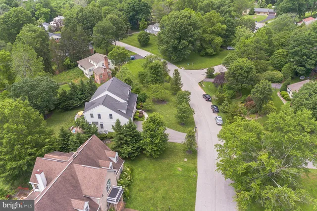 an aerial view of a house with swimming pool and couple of trees
