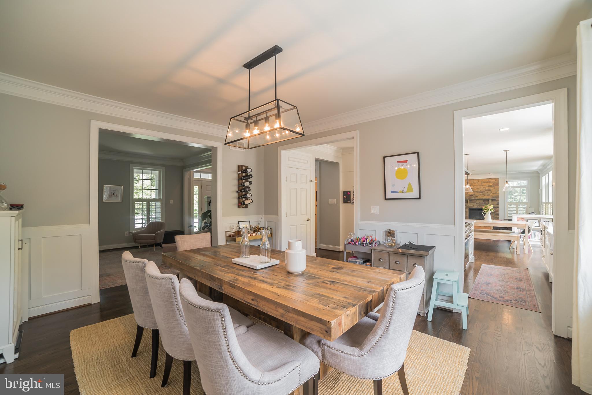 3746 Spring Meadow Drive Ellicott City, MD 21042 - Photo 6 of 40 a dining room with wooden floor a chandelier a wooden table and chairs