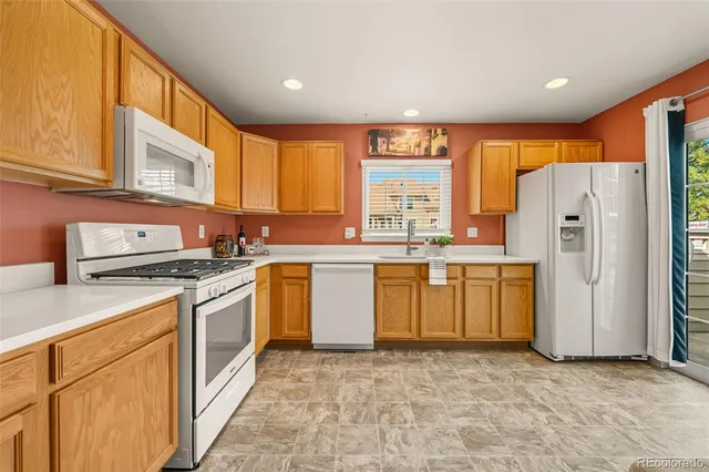 a kitchen with a refrigerator sink stove and cabinets