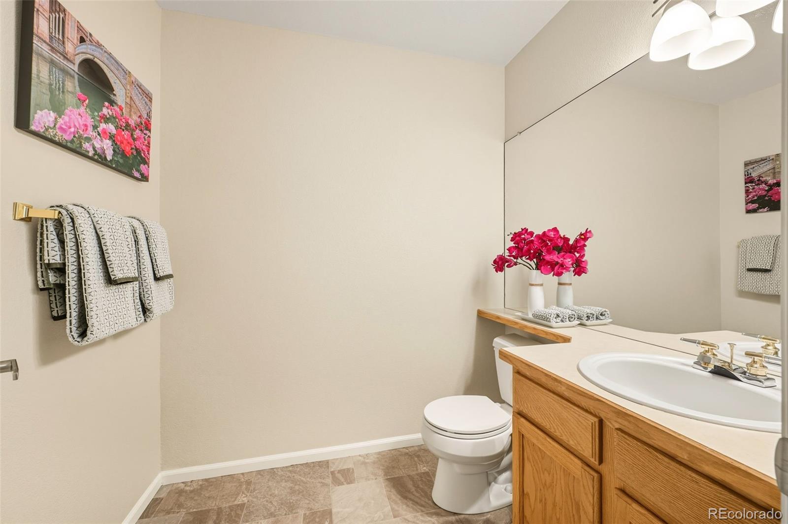 10058 Grove Court, Unit E Westminster, CO 80031 - Photo 30 of 48 a bathroom with a sink vanity and a toilet