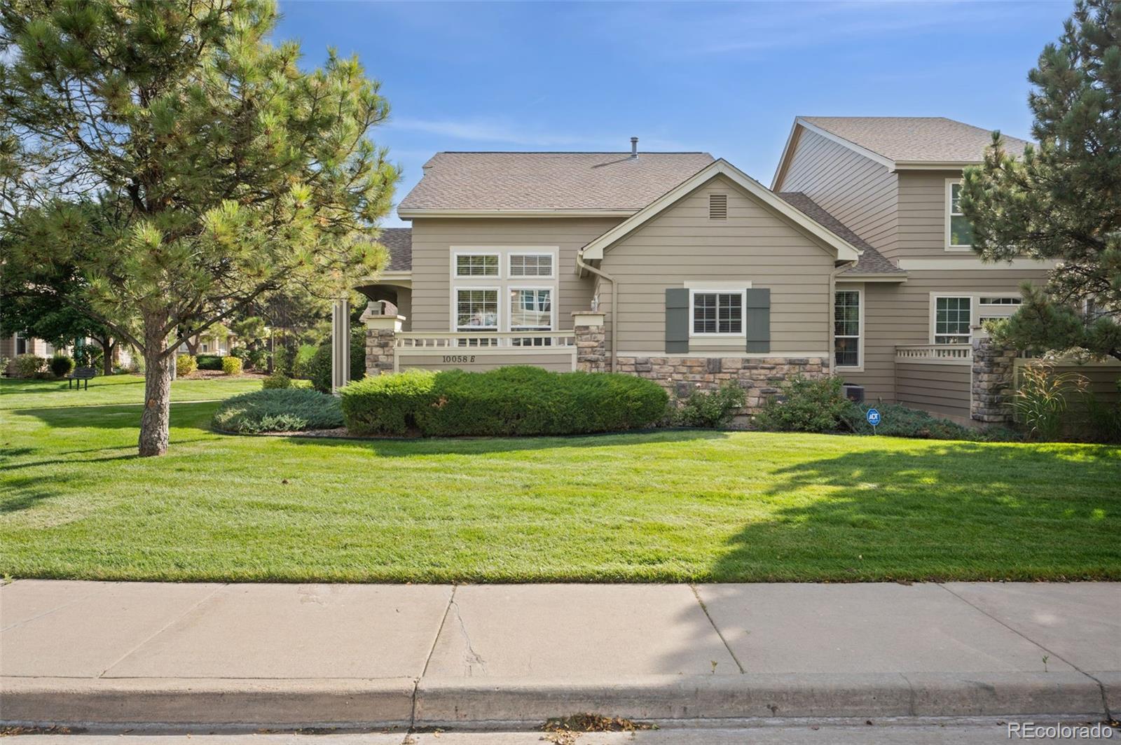 10058 Grove Court, Unit E Westminster, CO 80031 - Photo 3 of 48 a view of a house next to a yard with big trees