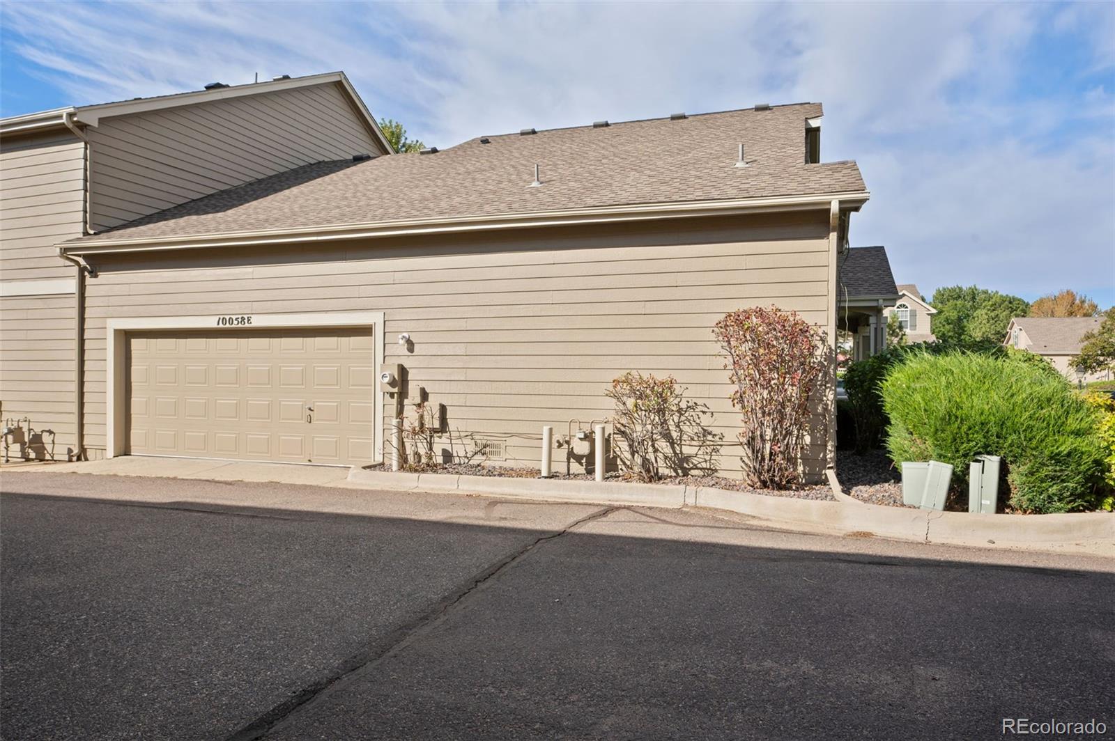 10058 Grove Court, Unit E Westminster, CO 80031 - Photo 37 of 48 a front view of a house with a yard and garage