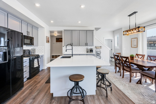 252 North Sunrise Rnch Drive Mapleton, UT 84664 - Photo 17 of 62 Open-concept kitchen and dining area featuring wood-finish flooring, light gray cabinetry, and white subway tile backsplash