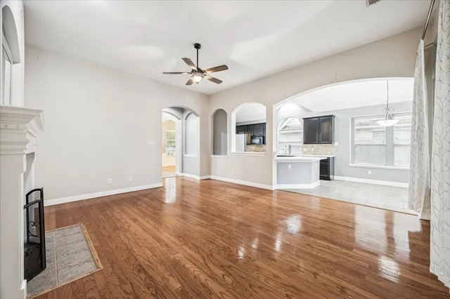 a view of an empty room with a kitchen and wooden floor