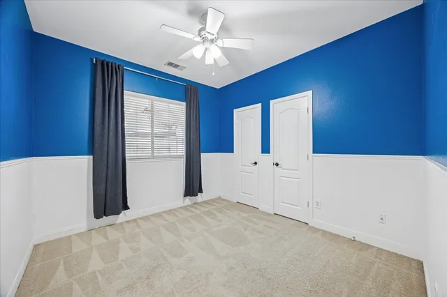 a view of a livingroom with an empty space and a ceiling fan