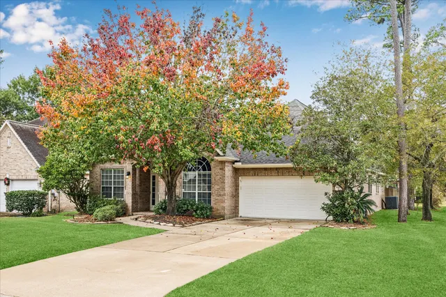 front view of a house with a yard and a tree