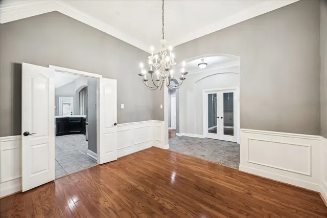 a view of a hallway with wooden floor and a chandelier