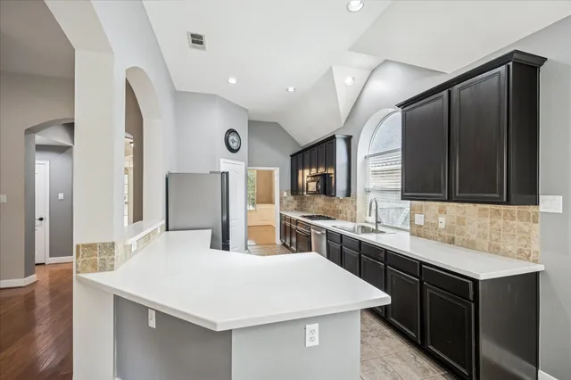 a kitchen with a sink a stove a refrigerator and cabinets