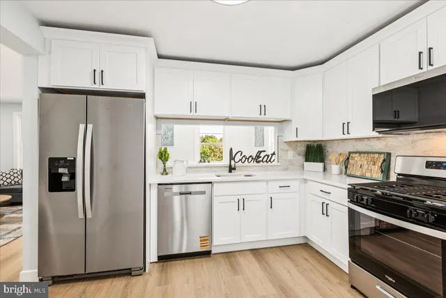 a kitchen with stainless steel appliances a refrigerator sink and microwave