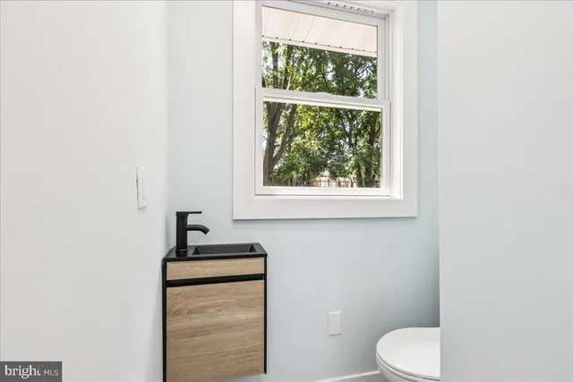 a bathroom with a toilet a sink and a window