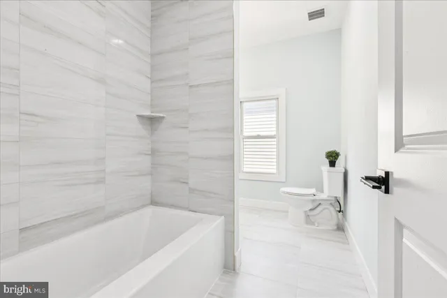 a bath tub sitting next to a white toilet