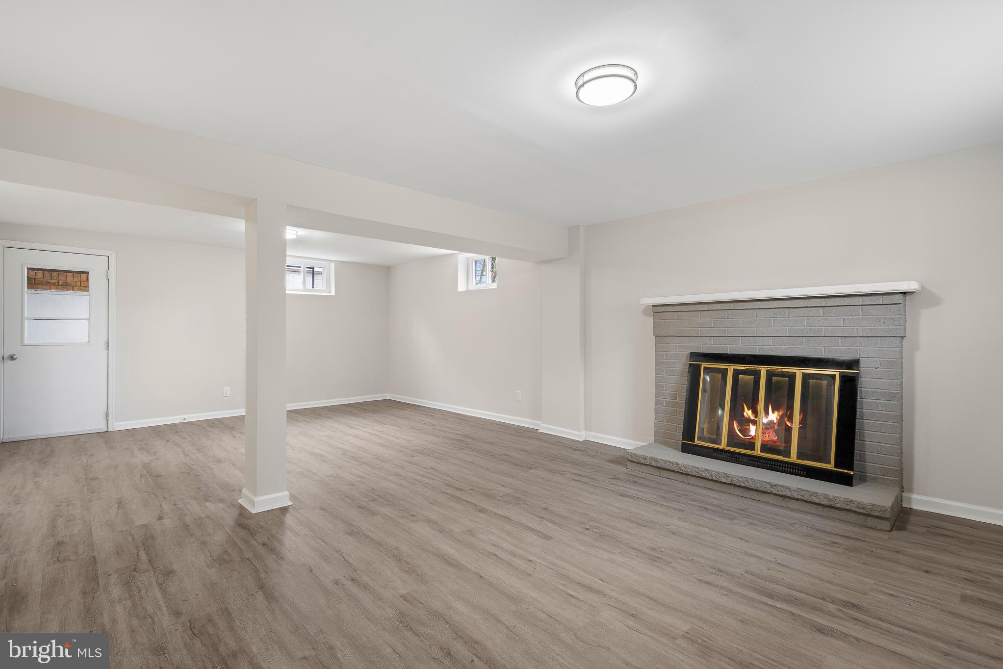 7804 D'Arcy Road District Heights, MD 20747 - Photo 23 of 61 an empty room with wooden floor and fireplace