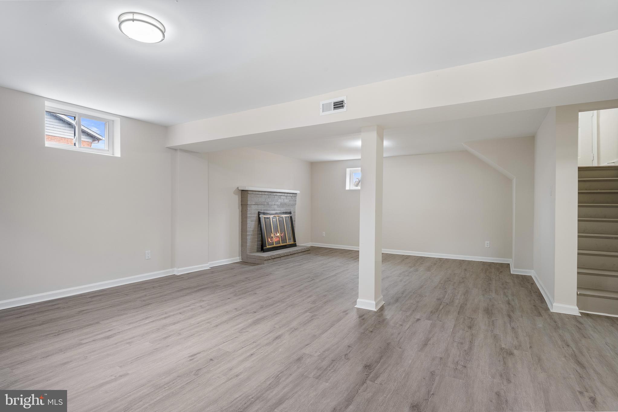 7804 D'Arcy Road District Heights, MD 20747 - Photo 30 of 61 an empty room with wooden floor fireplace and windows