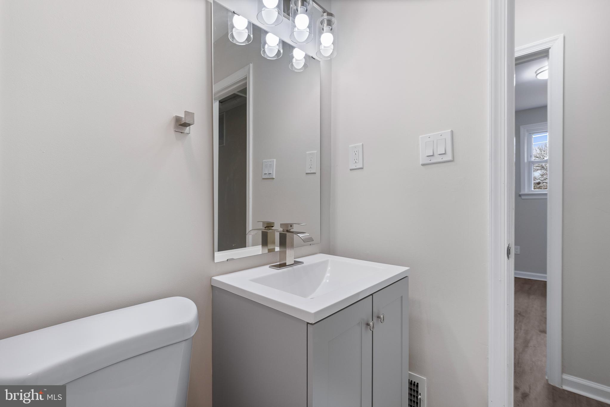 7804 D'Arcy Road District Heights, MD 20747 - Photo 41 of 61 a bathroom with a sink a toilet and a mirror