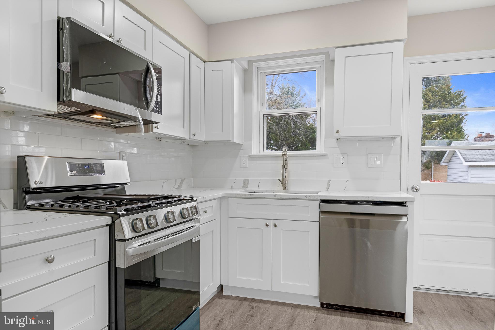 7804 D'Arcy Road District Heights, MD 20747 - Photo 8 of 61 a kitchen with stainless steel appliances a stove a microwave and sink