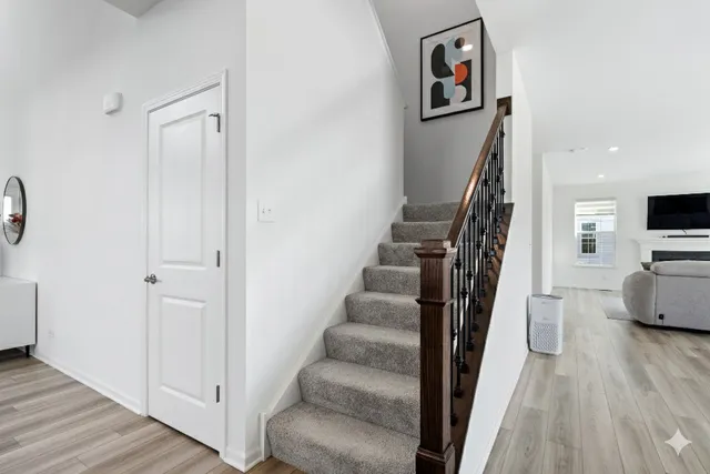a view of a hallway with wooden floor and staircase