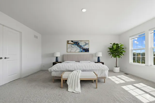 a bedroom with bed and a potted plant on table