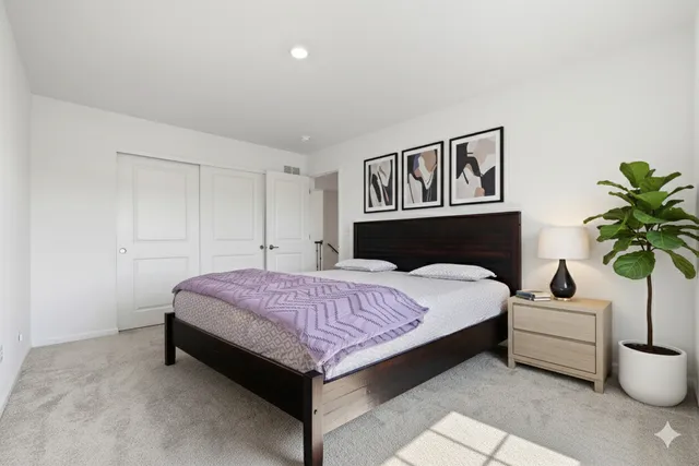 a spacious bedroom with a bed and a potted plant