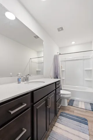 a bathroom with a sink a toilet and a large mirror