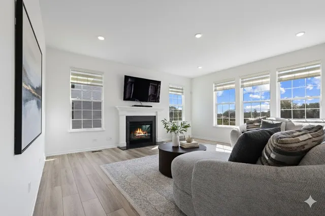 a living room with furniture a flat screen tv and a fireplace
