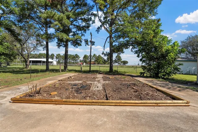 a view of a house with a big yard and large trees