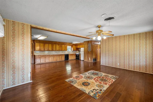 a view of a livingroom with wooden floor and a ceiling fan