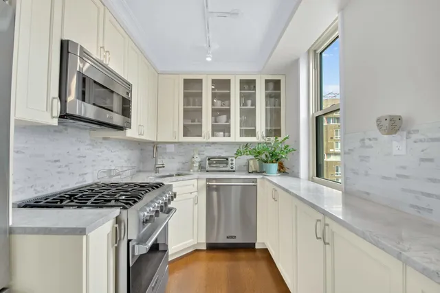 a kitchen with stainless steel appliances granite countertop a stove and a microwave