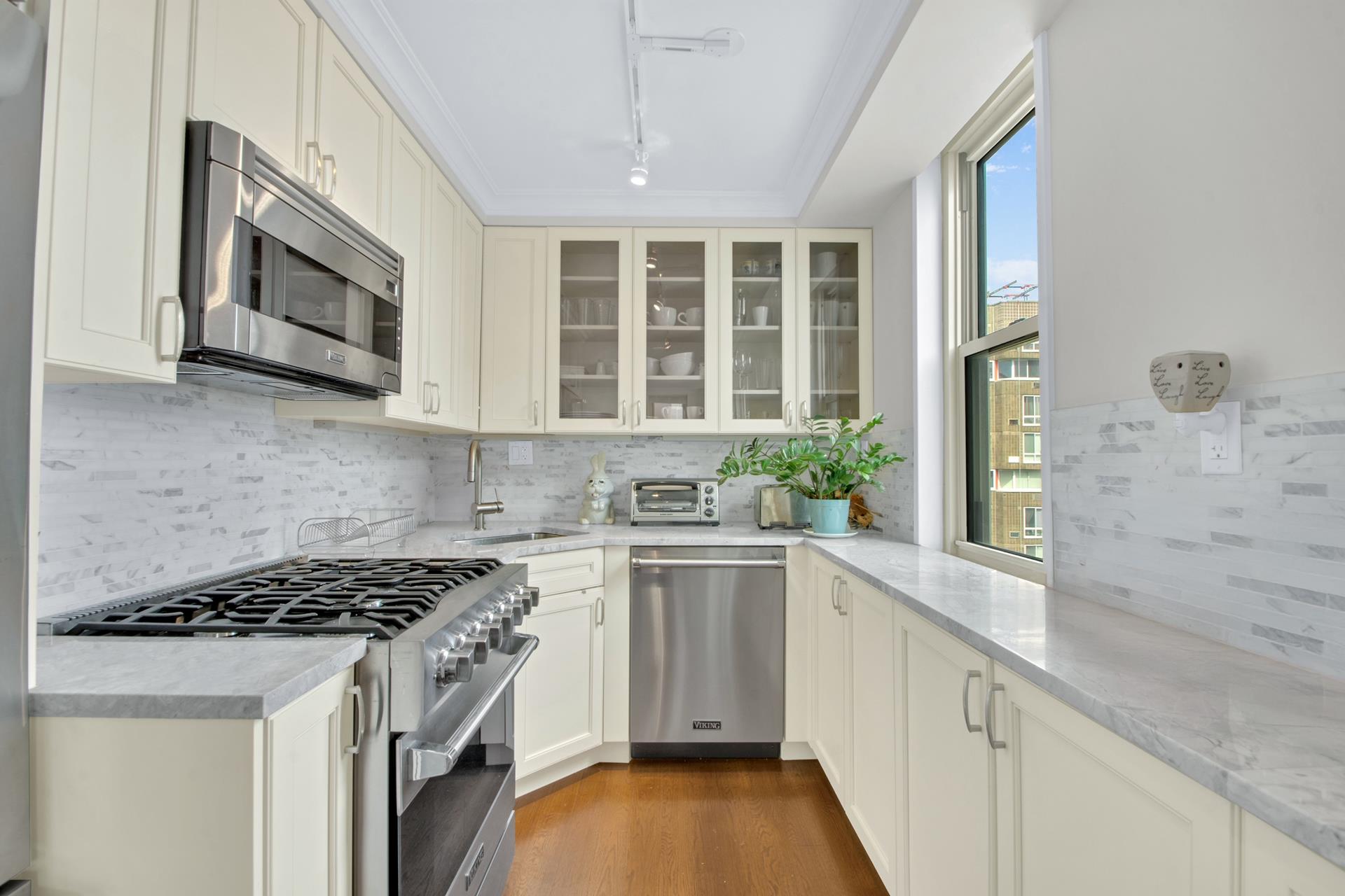 575 Main Street, Unit 1611 Manhattan, NY 10044 - Photo 2 of 9 a kitchen with stainless steel appliances granite countertop a stove and a microwave