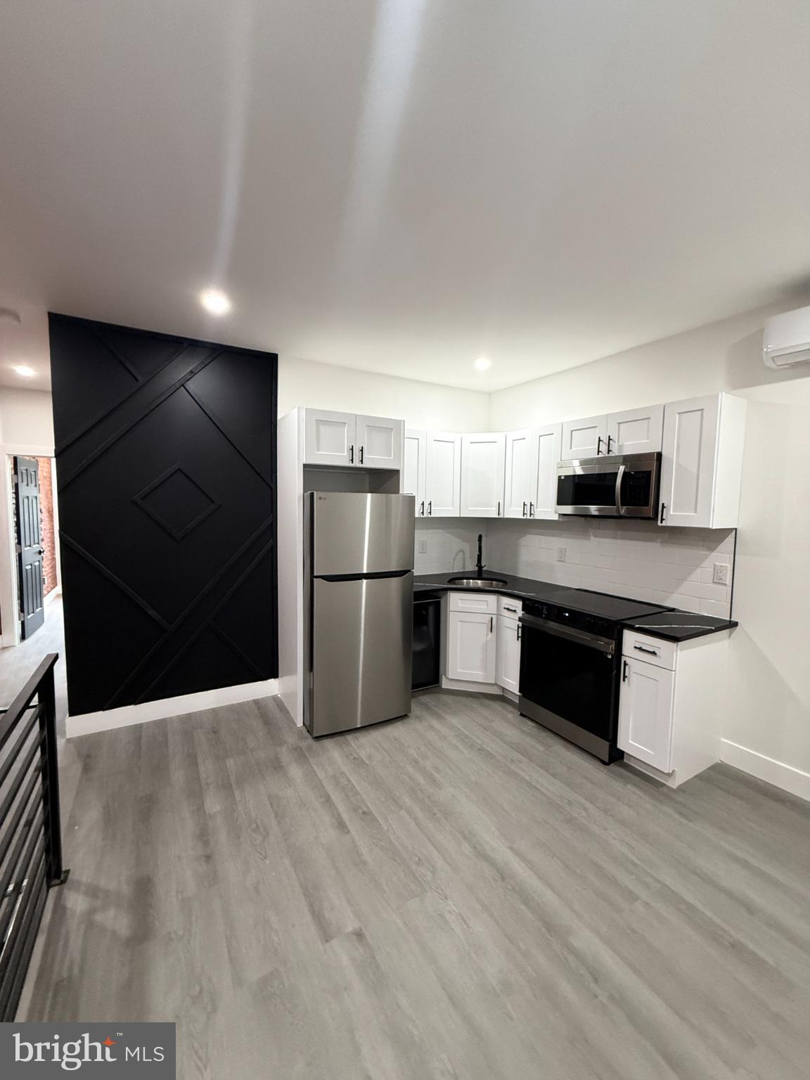 a kitchen with granite countertop a refrigerator and a stove top oven