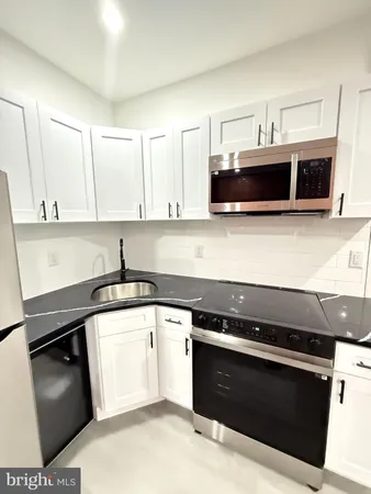 a kitchen with stainless steel appliances kitchen island granite countertop a refrigerator and a stove top oven