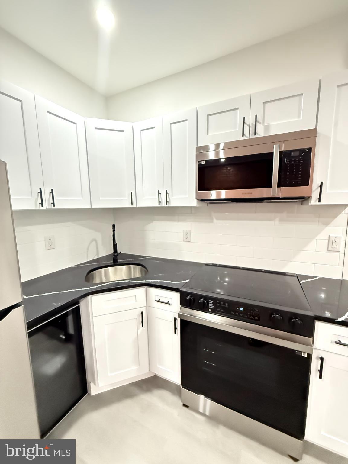 4539 North 18th Street Philadelphia, PA 19140 - Photo 13 of 25 a kitchen with granite countertop a stove and a sink