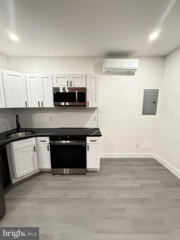 a view of kitchen with refrigerator stove and wooden floor