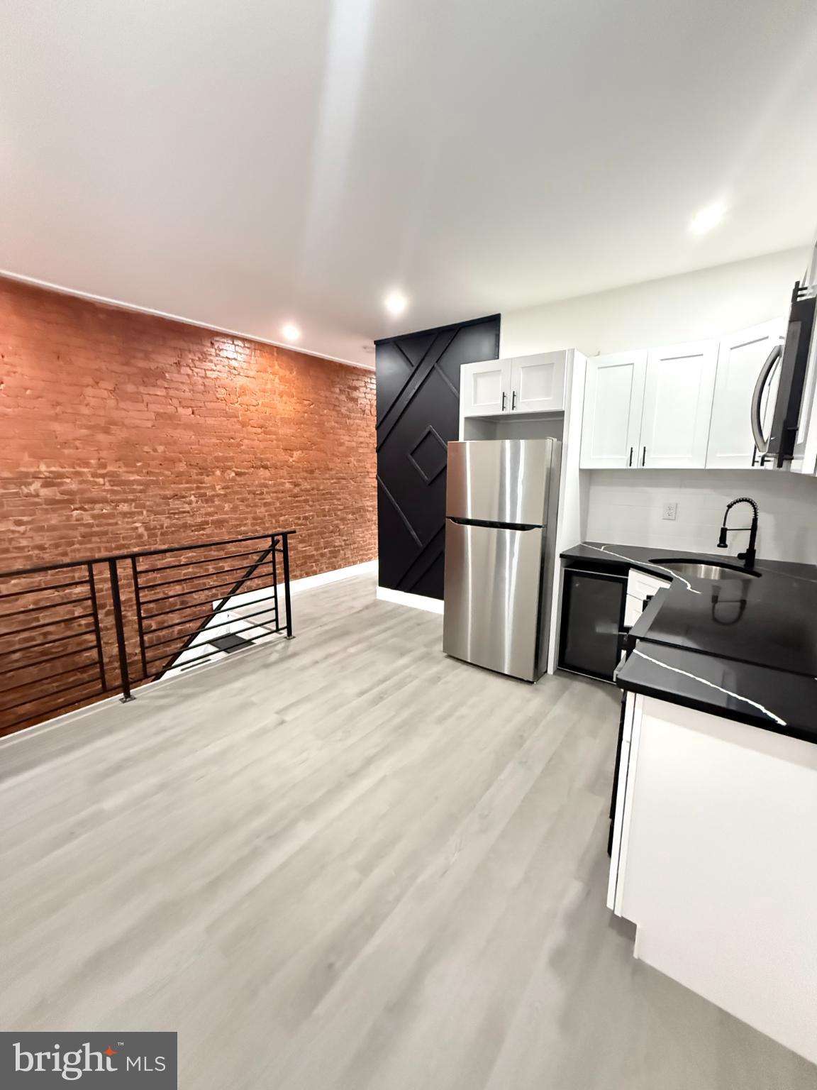 4539 North 18th Street Philadelphia, PA 19140 - Photo 15 of 25 a kitchen with stainless steel appliances kitchen island granite countertop a refrigerator and a stove top oven