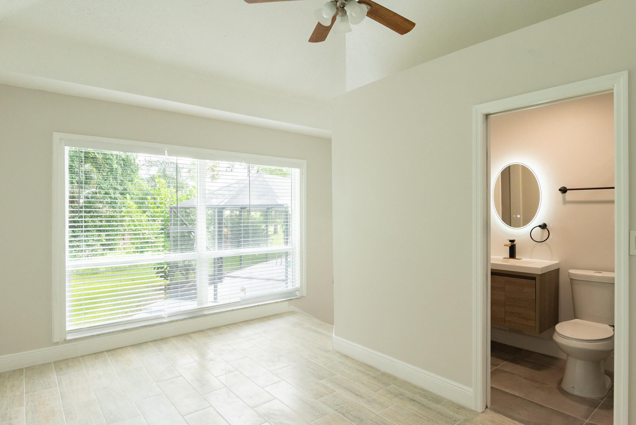 3441 Southeast Court Drive Stuart, FL 34997 - Photo 24 of 46 a bathroom with a toilet a sink and a window