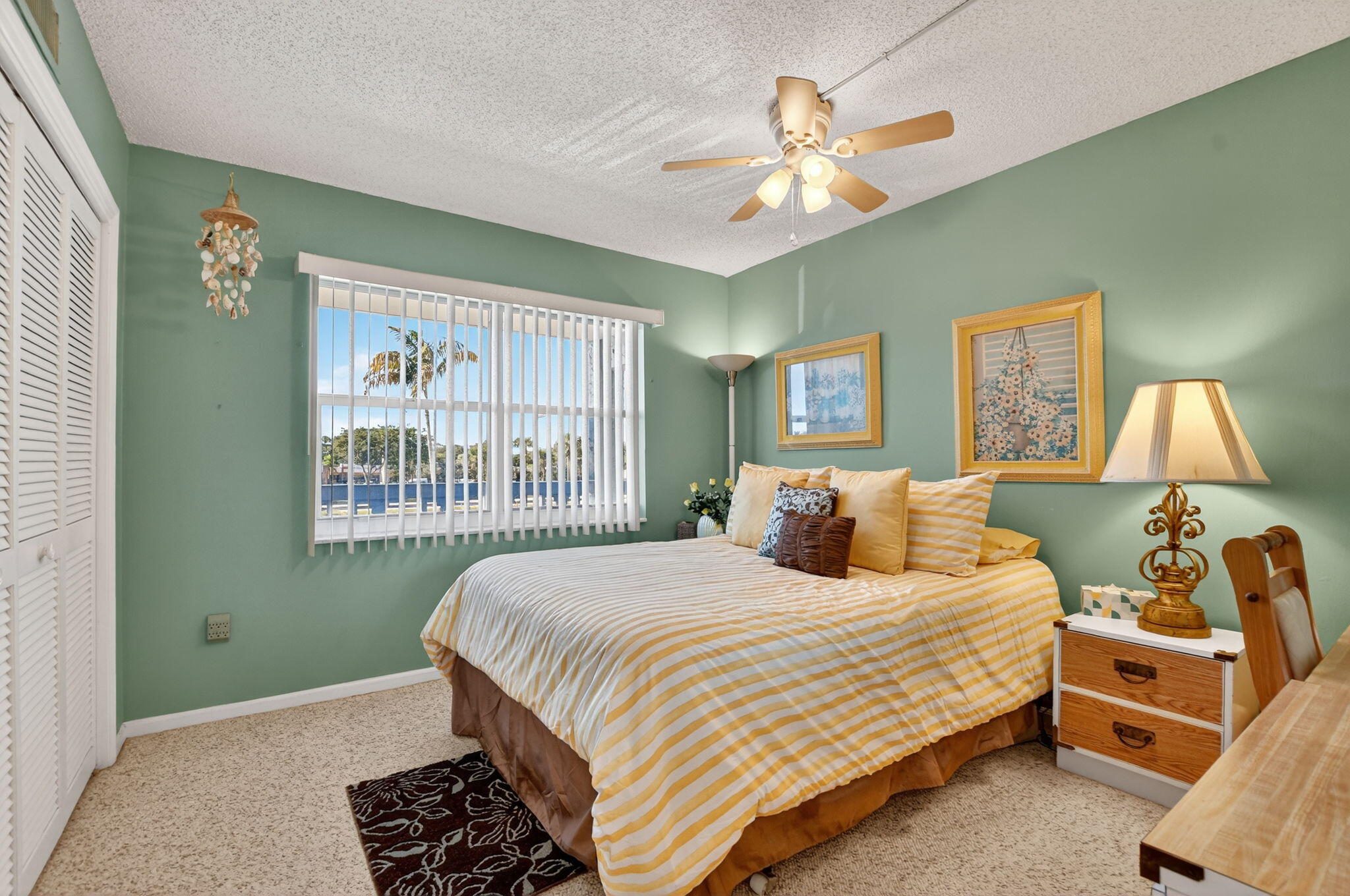 9880 Marina Boulevard, Unit 1522 Boca Raton, FL 33428 - Photo 13 of 52 a bedroom with a bed a window and a chandelier