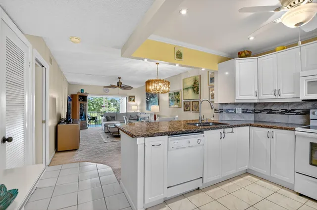 a kitchen with granite countertop a sink and cabinets