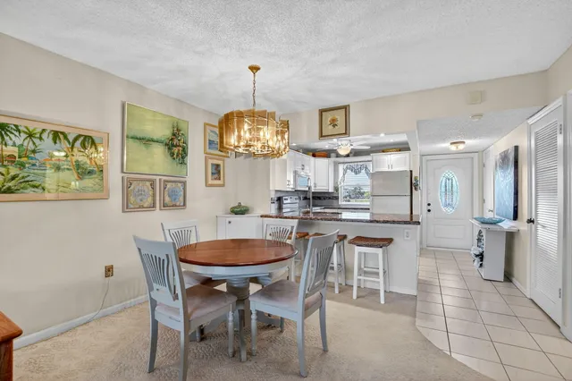 a dining room with furniture a kitchen view and a chandelier