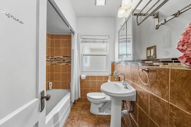 a bathroom with a sink a toilet a mirror and bathtub