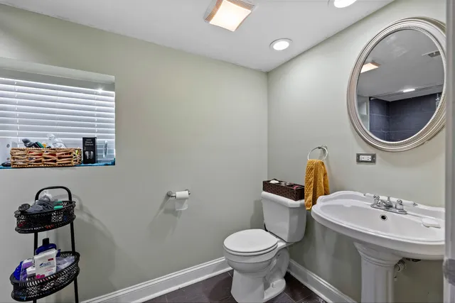 a bathroom with a toilet sink and mirror