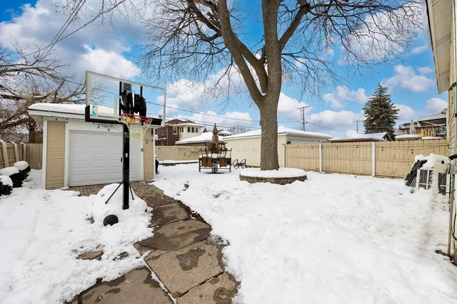 a view of a backyard with snow on the road