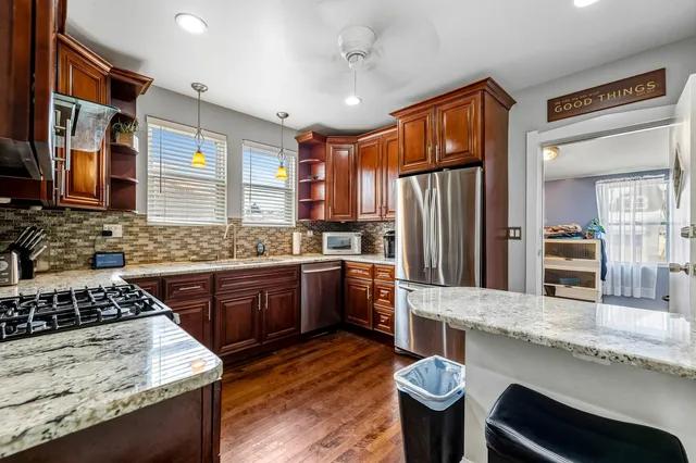 a kitchen with stainless steel appliances granite countertop a stove refrigerator sink and dishwasher
