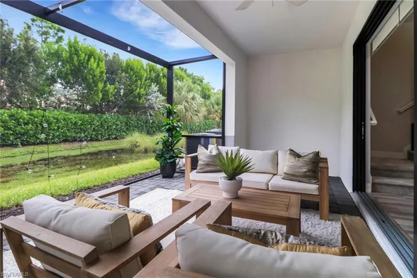 a view of a patio with couches plants and outdoor view