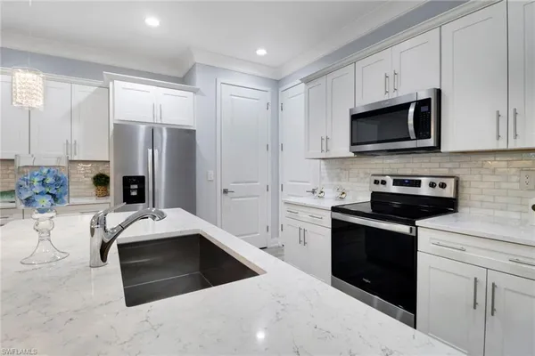 a kitchen with stainless steel appliances a stove sink microwave refrigerator and cabinets